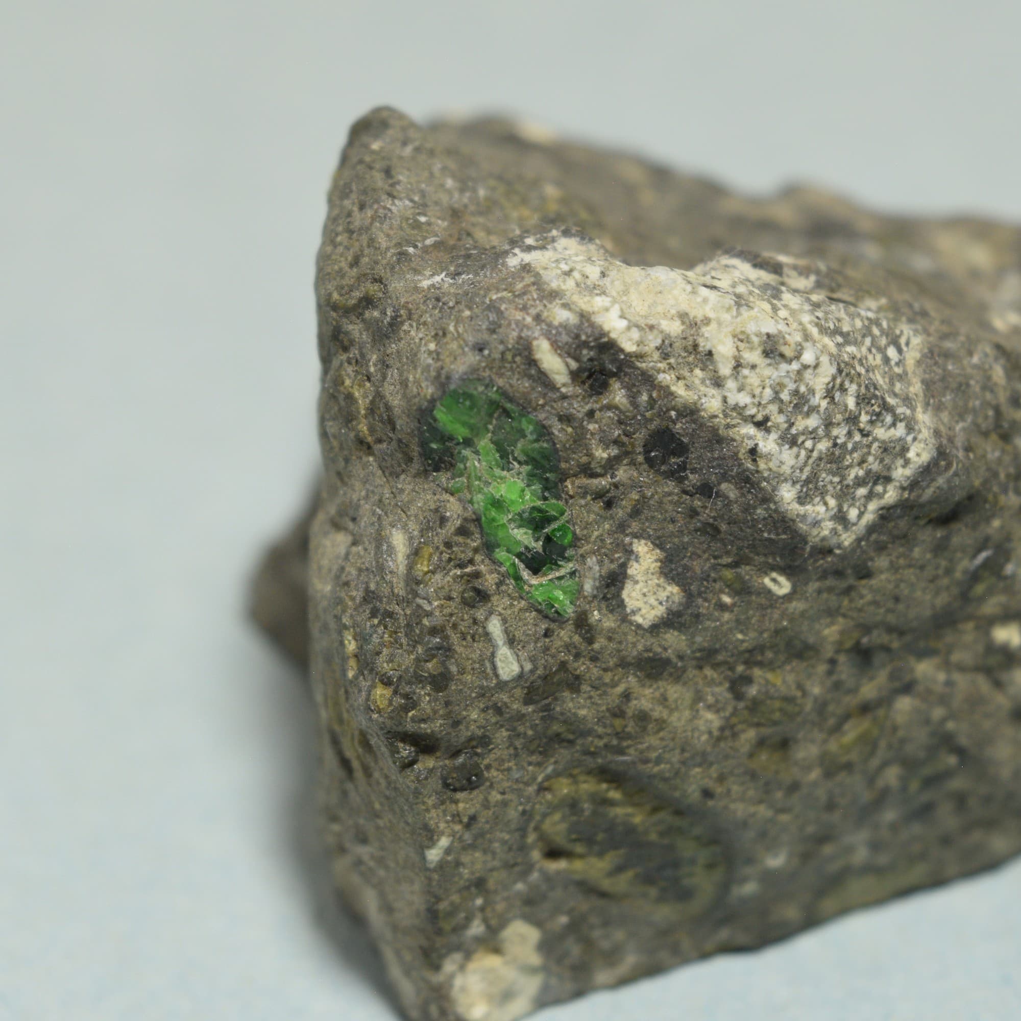 Bright green chrome diopside crystal embedded in kimberlite matrix